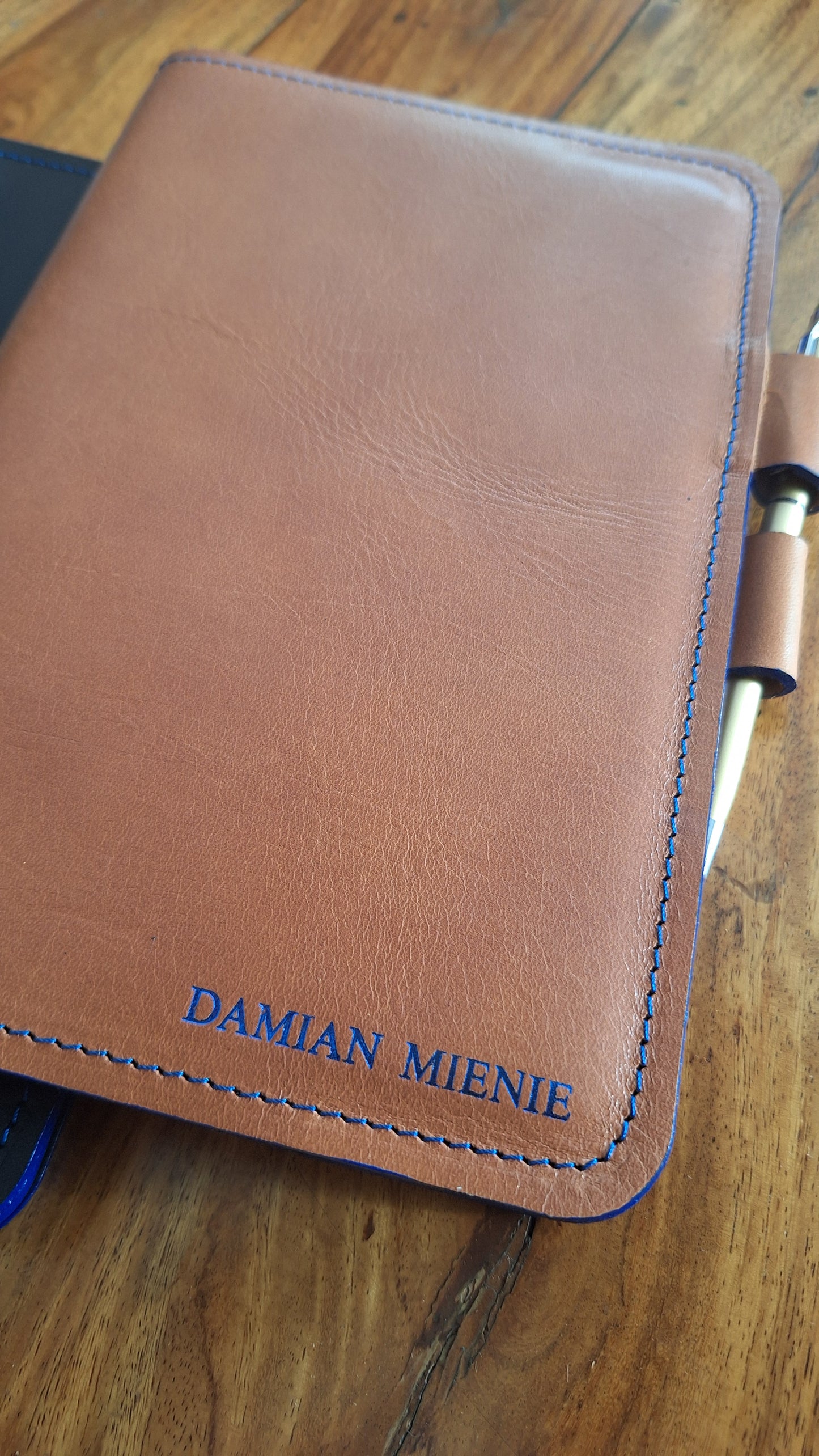 Tan leather notebook cover with blue foiling and blue edge paint