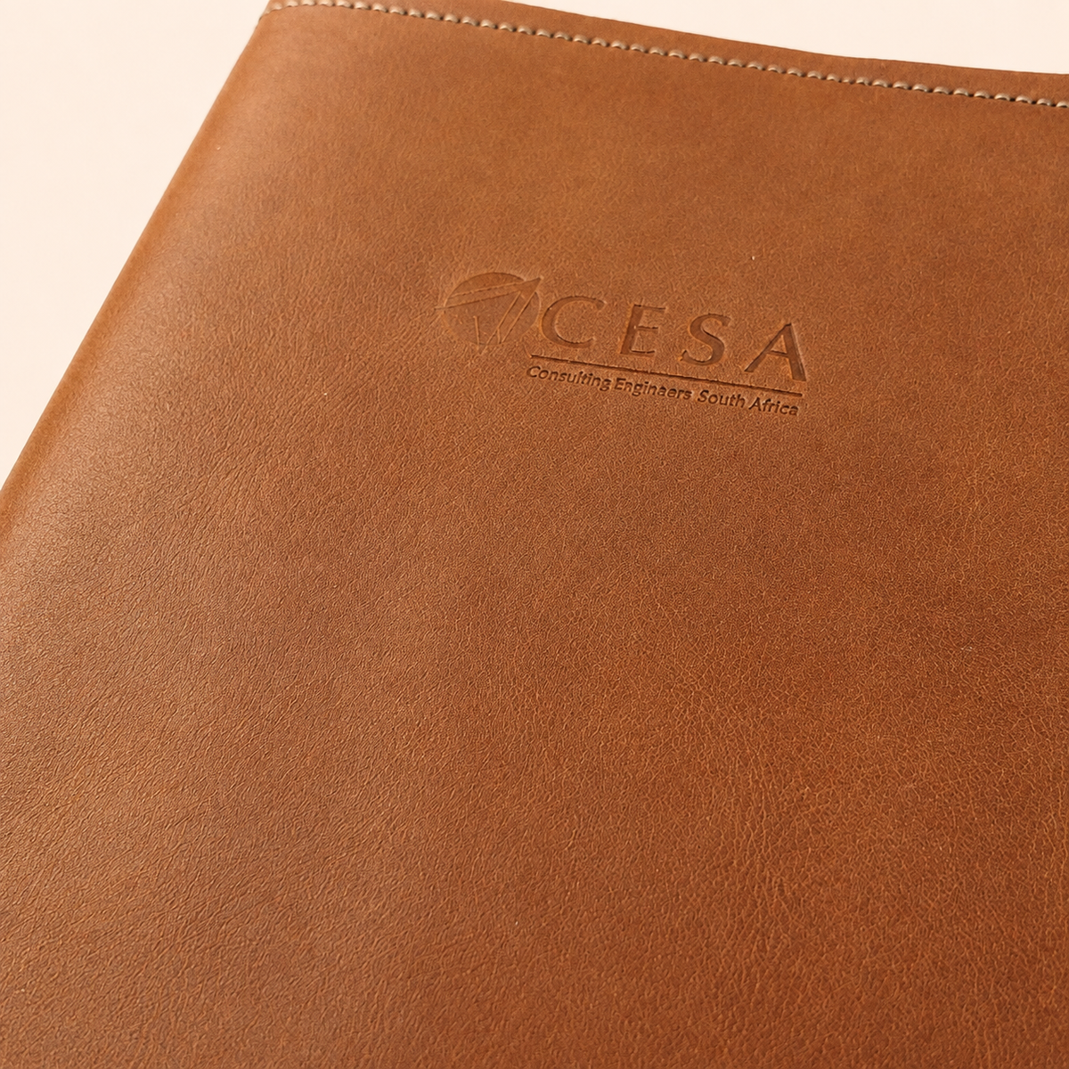 Close-up of custom debossed company logo on A5 leather notebook cover