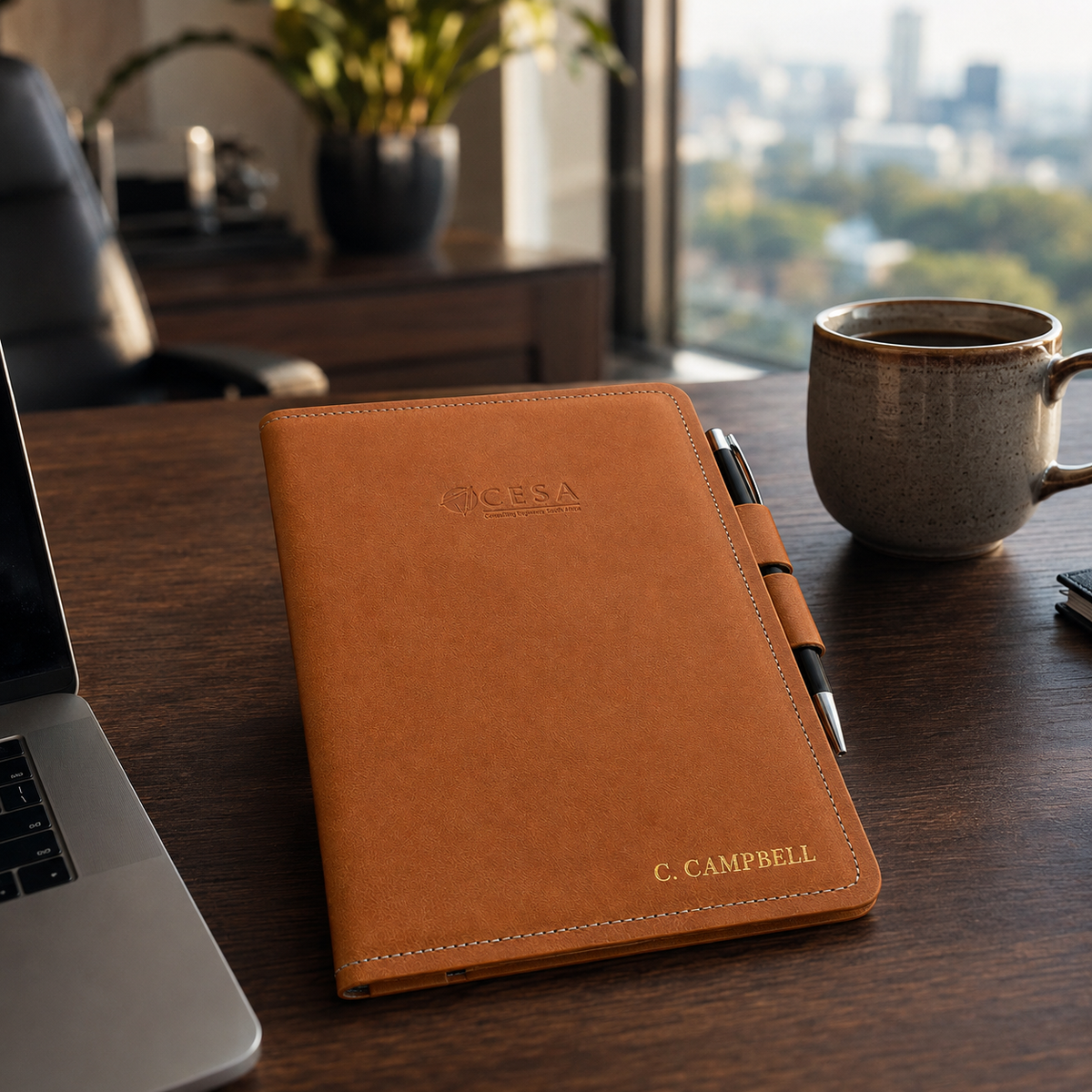 Personalised A5 leather notebook cover with pen-lock closure on an executive office desk